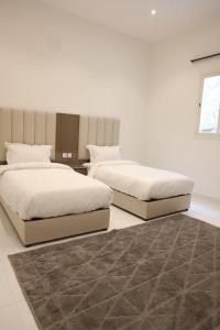 two beds sitting next to each other in a bedroom at شاليهات تايم in Khamis Mushayt
