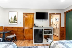 a living room with a microwave and a tv at The Inn at the Rostay in Bethel
