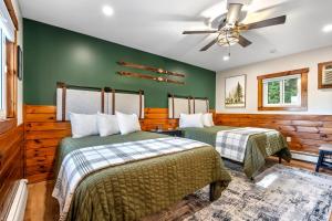 two beds in a room with green walls at The Inn at the Rostay in Bethel