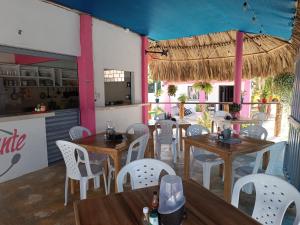 a restaurant with wooden tables and white chairs at Alojamiento Matuzalen in Coveñas
