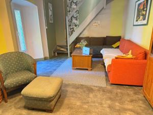 a living room with a couch and a chair at Le Kompost'l dortoir en gîte 4 place in Saint-Privat-dʼAllier