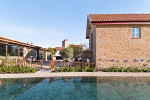 a swimming pool in front of a building at RioVerde Agroturismo in Barcelos