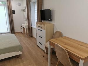 a bedroom with a table and a television on a dresser at Happy Home1 in Cahul