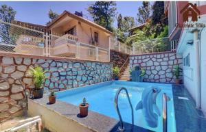 a house with a swimming pool next to a building at CHOCOLATE VILLA Mahabaleshwar in Mahabaleshwar