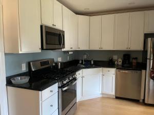 a kitchen with white cabinets and a stove top oven at Cozy 1Br Apt in Bangor