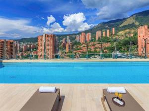 a swimming pool with a view of a city at Novotel Medellin El Tesoro in Medellín