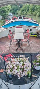 a table and chairs and flowers on a boat at Péniche ALEGRIA in Poilhès