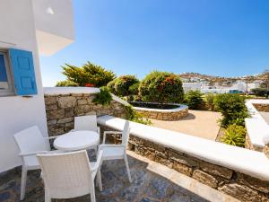 a patio with a table and chairs on a wall at Eleftheria Hotel & Apartments in Ornos