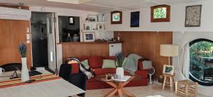 a living room with a red couch and a table at Péniche ALEGRIA in Poilhès
