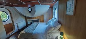 a bedroom with a bed in a small room at Péniche ALEGRIA in Poilhès