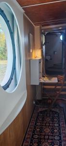 a small room with a round window and a desk at Péniche ALEGRIA in Poilhès +23 photos