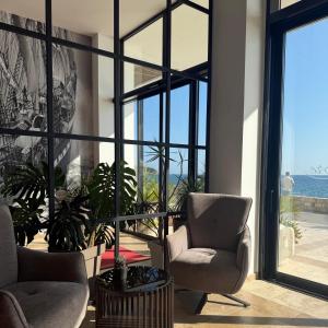 a living room with two chairs and a large window at Hotel Sutomore & Apartments in Sutomore +6 photos