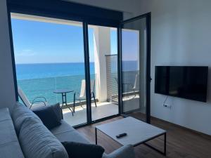 a living room with a couch and a view of the ocean at Hotel Sutomore & Apartments in Sutomore