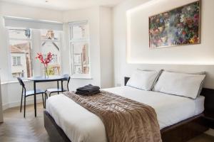 a bedroom with a bed and a table and window at Harrow Boutique Suites in Harrow