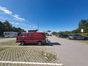 a red van parked in a parking lot at Retro Kamper Jastarnia in Jastarnia +119 photos