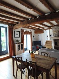 a living room with a wooden table and chairs at La petite maison d'à côté in Noyers +20 photos