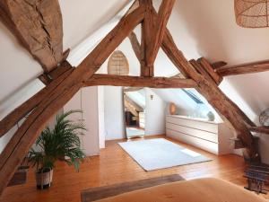 an attic room with a large wooden beam ceiling at La petite maison d'à côté in Noyers