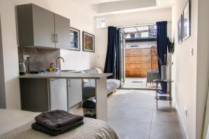 a kitchen with a sink and a table in a room at Harrow Boutique Suites in Harrow