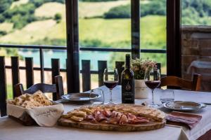 a table with a plate of food and wine glasses at La Corte Sul Lago in Cingoli