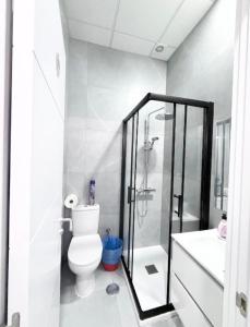 a white bathroom with a shower and a toilet at Hostel LAS ROSAS in Madrid +9 photos