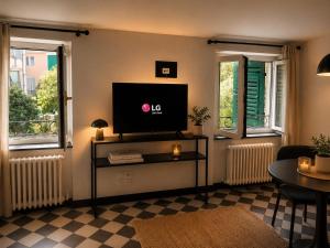 a living room with a flat screen tv and two windows at Maison Cecilia in Rapallo