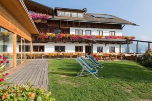 a building with chairs and tables in the yard at Berggasthof Häusler in San Lorenzo di Sebato