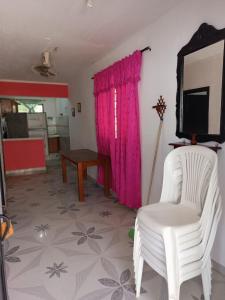 a living room with a tv and a white chair at Alojamiento Matuzalen in Coveñas