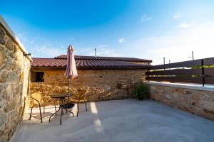 a patio with a table and chairs and a building at Casa Ataraxia II in Boiro