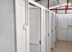a corridor with white doors in a building at Çıralı Camping in Cıralı