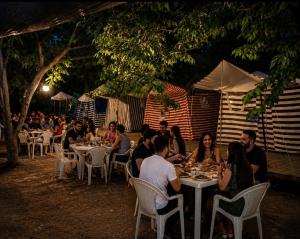 a group of people sitting at tables eating food at Çıralı Camping in Cıralı