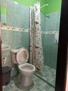 a bathroom with a toilet and a shower curtain at Alojamiento Matuzalen in Coveñas +23 photos