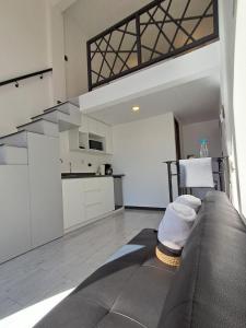 a living room with a couch and a kitchen at 7min del Parque Central-2min Rotonda Marimba, en la naturaleza Tipo LOFT5 in Quetzaltenango +23 photos