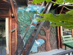 a ladder painted on the side of a building with a tree mural at Okan Rock Residence in Ella