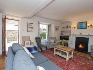 a living room with a blue couch and a fireplace at Agar Cottage in Port Isaac