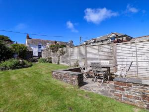 a patio with a table and chairs in a yard at Agar Cottage in Port Isaac