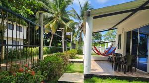 a porch with chairs and a hammock on a house at Cabaña Los Cristales Coveñas by Amauna in Coveñas