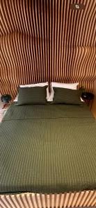 a bed with a green comforter on top at U House in São Paulo +29 photos