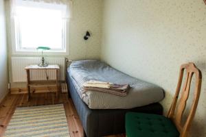 a small bedroom with a bed and a window at Allsta Gård Kretsloppshuset B&B in Bjärtrå