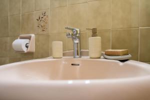 a bathroom sink with a faucet and two soap bottles at Agia Paraskevi Villa Olive in Makri +79 photos