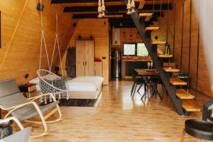 a room with a bed and a table and chairs at A-Forest Retreat - David's A-frame in Ocna-Mureşului