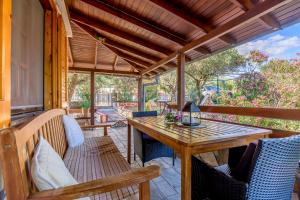 an outdoor patio with a wooden table and chairs at Agia Paraskevi Villa Olive in Makri
