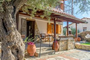 a house with a porch and a tree at Agia Paraskevi Villa Olive in Makri