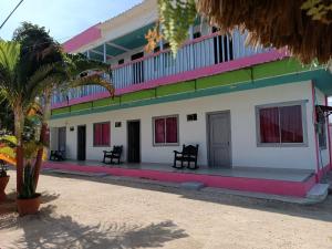 a building with colorful windows and a palm tree at Alojamiento Matuzalen in Coveñas