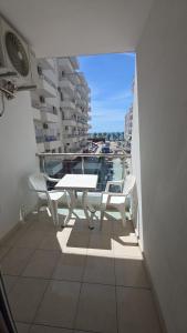 a balcony with a table and chairs on a building at Solei Sea Apartment in Shëngjin
