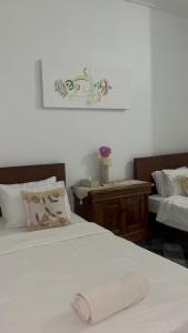 a bedroom with two beds with white sheets and a table at D,lacoco in Kubupenlokan