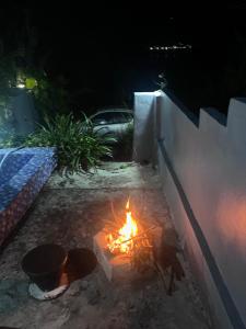 a fire burns in a backyard at night at D,lacoco in Kubupenlokan