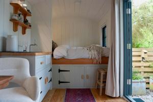 a kitchen with white cabinets and a window at Shepherds Hut in Penzance in Newlyn