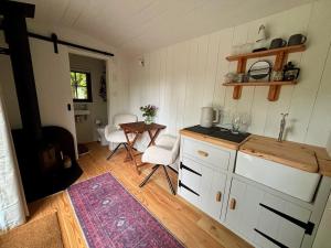 a kitchen with a counter and a table in a room at Shepherds Hut in Penzance in Newlyn