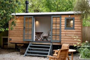 a tiny house with a table and two chairs at Shepherds Hut in Penzance in Newlyn