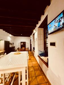 a dining room with a white table and a flat screen tv at Coliving Tenerife - Villa La Laguna in Las Lagunas